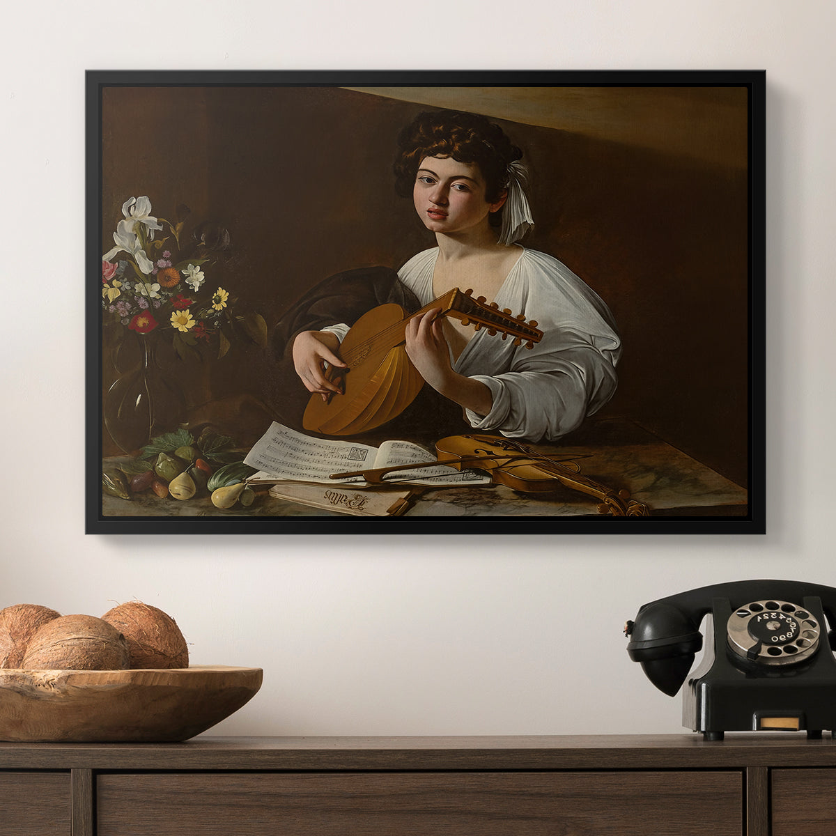 The Lute Player (Hermitage Version), c. 1596 by Caravaggio in a black floater framed canvas displayed above a console table in a hallway, featuring a Baroque depiction of musician with detailed textures and lighting.