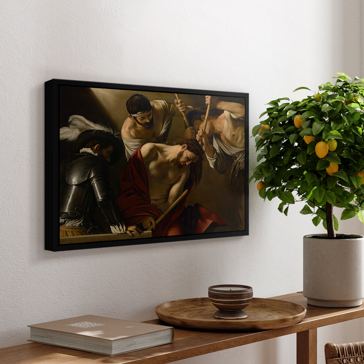 The Crowning with Thorns (Vienna Version), c. 1602-1604 by Caravaggio, presented in a black floater framed canvas featuring Christ surrounded by men pressing crown of thorns onto his head, displayed above a hallway console table.