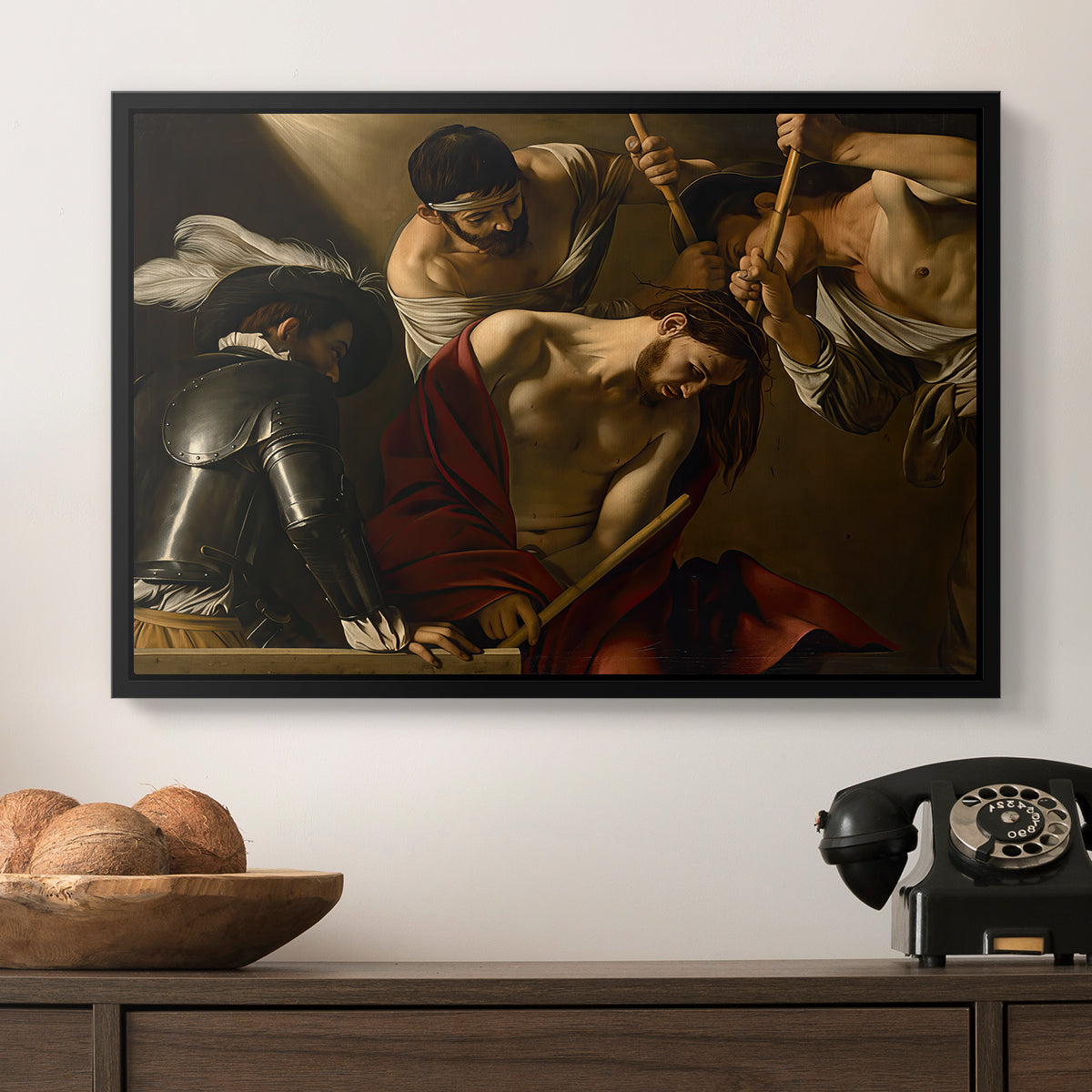 The Crowning with Thorns (Vienna Version), c. 1602-1604 by Caravaggio in a black floater framed canvas displayed above a console table in a hallway, featuring an intense religious composition with strong shadow and physical struggle.