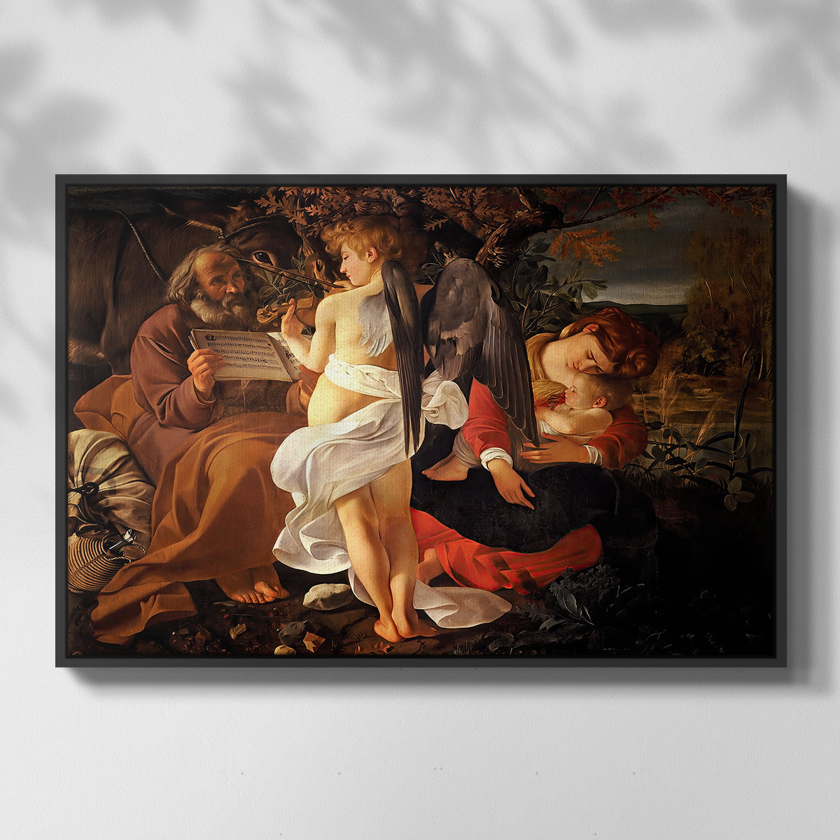Front view of Rest on the Flight into Egypt, c. 1597 by Caravaggio in a black floater framed canvas.