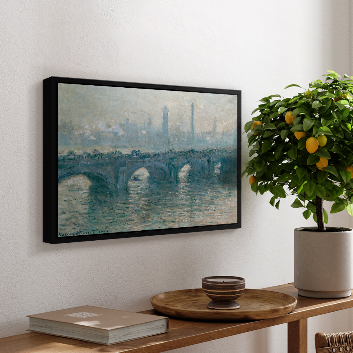 Waterloo Bridge, Gray Weather, 1900 by Claude Monet, presented in a black floater framed canvas featuring a hazy view of Waterloo Bridge over river in gray atmospheric light, displayed above a hallway console table.