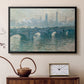 Black floater framed canvas featuring a soft-toned river scene with bridge and muted skyline, displayed above a cabinet in a soft-toned living room.