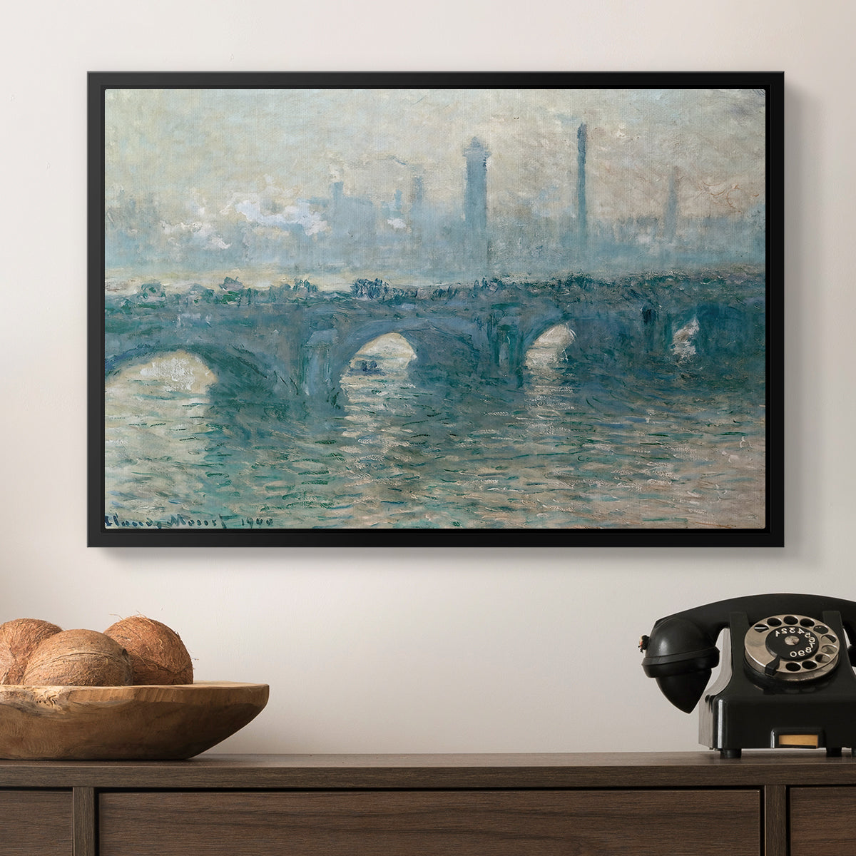 Waterloo Bridge, Gray Weather, 1900 by Claude Monet in a black floater framed canvas displayed above a console table in a hallway, featuring an atmospheric urban landscape with misty light and reflections.