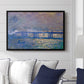Charing Cross Bridge, 1903 by Claude Monet displayed above a sofa in a living room in a black floater frame, featuring an urban landscape with bridge and water rendered in blurred tones.