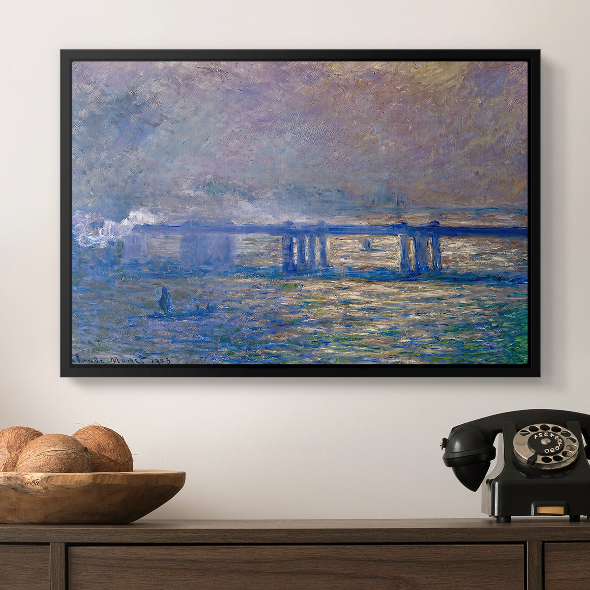 Charing Cross Bridge, 1903 by Claude Monet in a black floater framed canvas displayed above a console table in a hallway, featuring a city bridge scene softened by mist and impressionist brushwork.