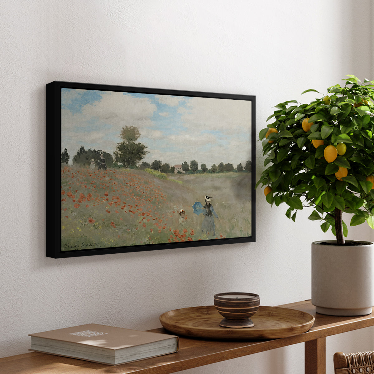 The Poppy Field near Argenteuil, 1873 by Claude Monet, presented in a black floater framed canvas featuring a field of red poppies with figures walking across rolling landscape, displayed above a hallway console table.