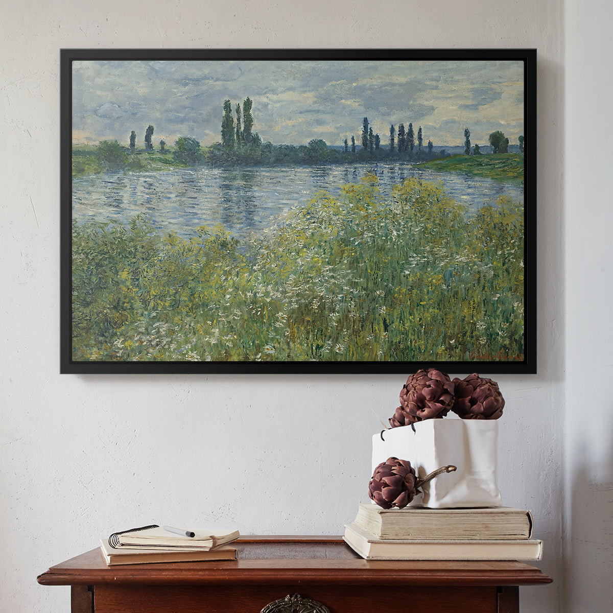Black floater framed canvas featuring Banks of the Seine, Vétheuil, 1880 by Claude Monet above an entryway table in a minimalist foyer.