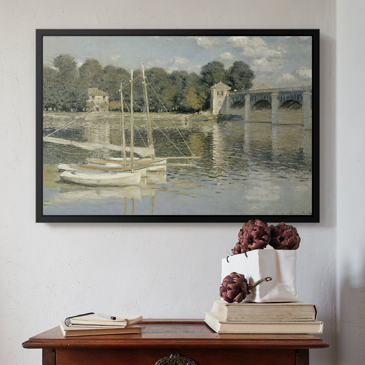 Black floater framed canvas featuring The Bridge at Argenteuil, 1874 by Claude Monet above an entryway table in a minimalist foyer.