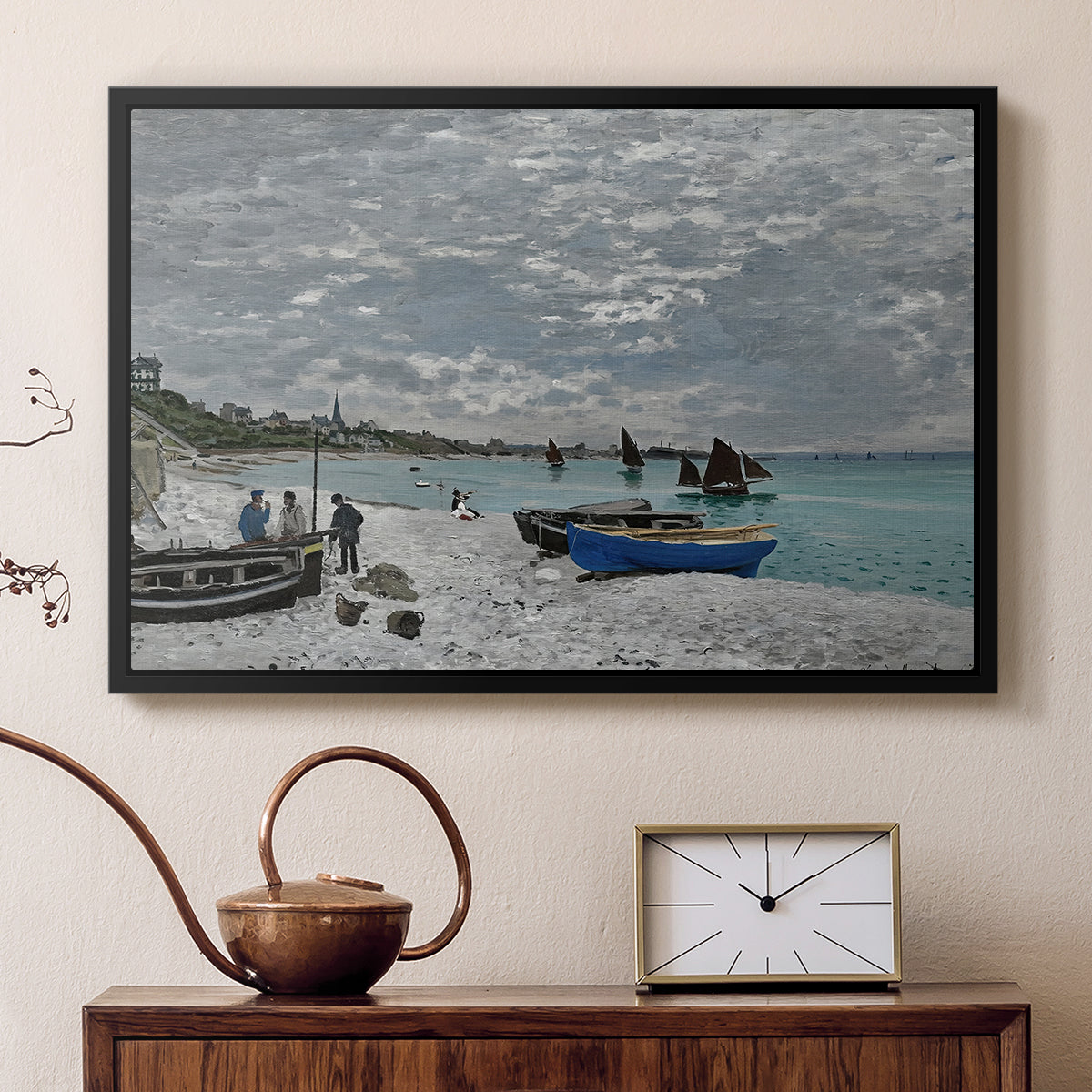 Black floater framed canvas featuring a coastal landscape with sailboats and visitors on cliffside, displayed above a cabinet in a soft-toned living room.