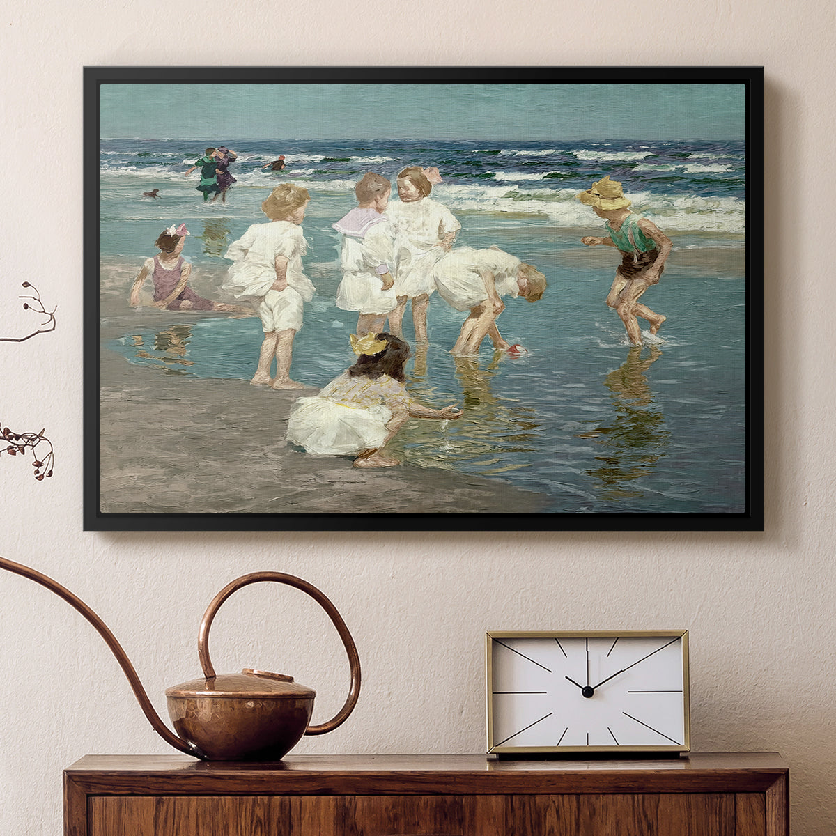 Black floater framed canvas featuring an impressionist coastal view of families enjoying seaside water, displayed above a cabinet in a soft-toned living room.