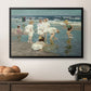 A Holiday, c. 1915 by Edward Henry Potthast in a black floater framed canvas displayed above a console table in a hallway, featuring a lively shoreline scene with people gathered in surf.