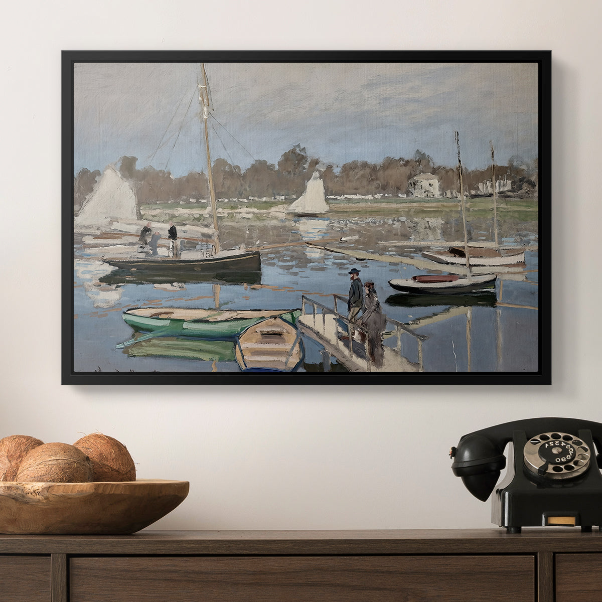 The Basin at Argenteuil, 1874 by Claude Monet in a black floater framed canvas displayed above a console table in a hallway, featuring a tranquil river setting with sailboats and shoreline.