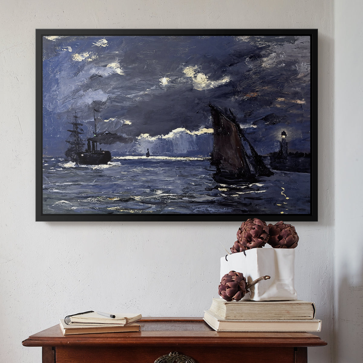 Black floater framed canvas featuring A Seascape, Shipping by Moonlight, 1864 by Claude Monet above an entryway table in a minimalist foyer.