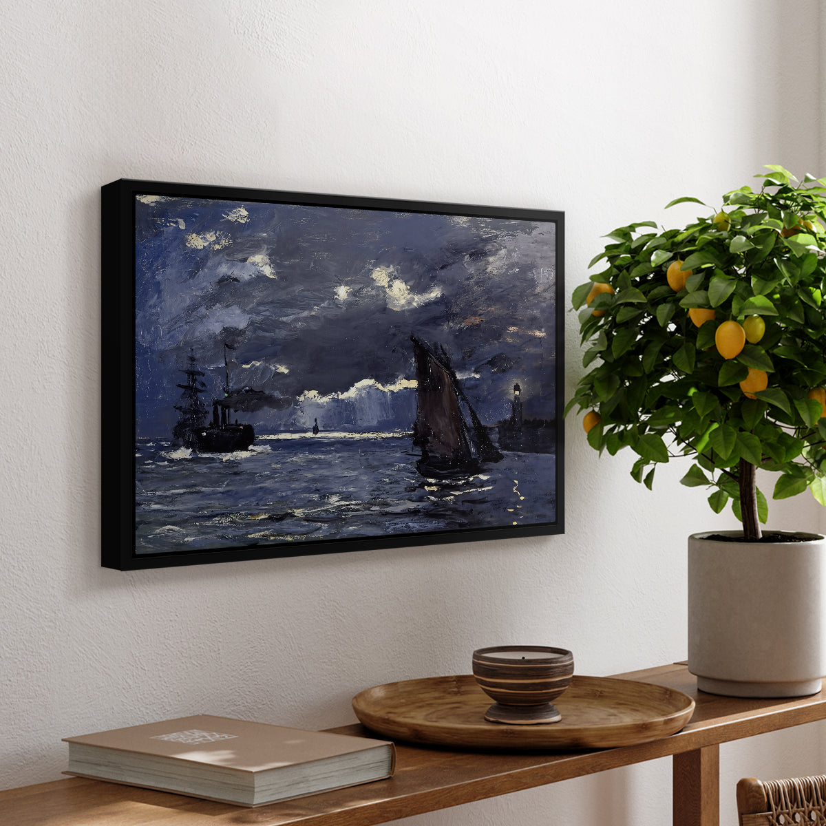 A Seascape, Shipping by Moonlight, 1864 by Claude Monet, presented in a black floater framed canvas featuring ships on dark sea illuminated by moonlight under night sky, displayed above a hallway console table.