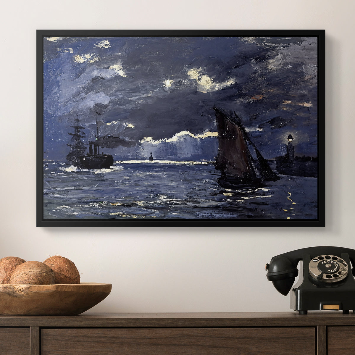 A Seascape, Shipping by Moonlight, 1864 by Claude Monet in a black floater framed canvas displayed above a console table in a hallway, featuring an atmospheric maritime view with ships in moonlit darkness.