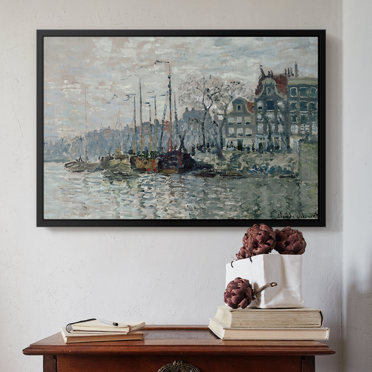 Black floater framed canvas featuring View of the Prins Hendrikkade and Kromme Waal in Amsterdam, 1874 by Claude Monet above an entryway table in a minimalist foyer.