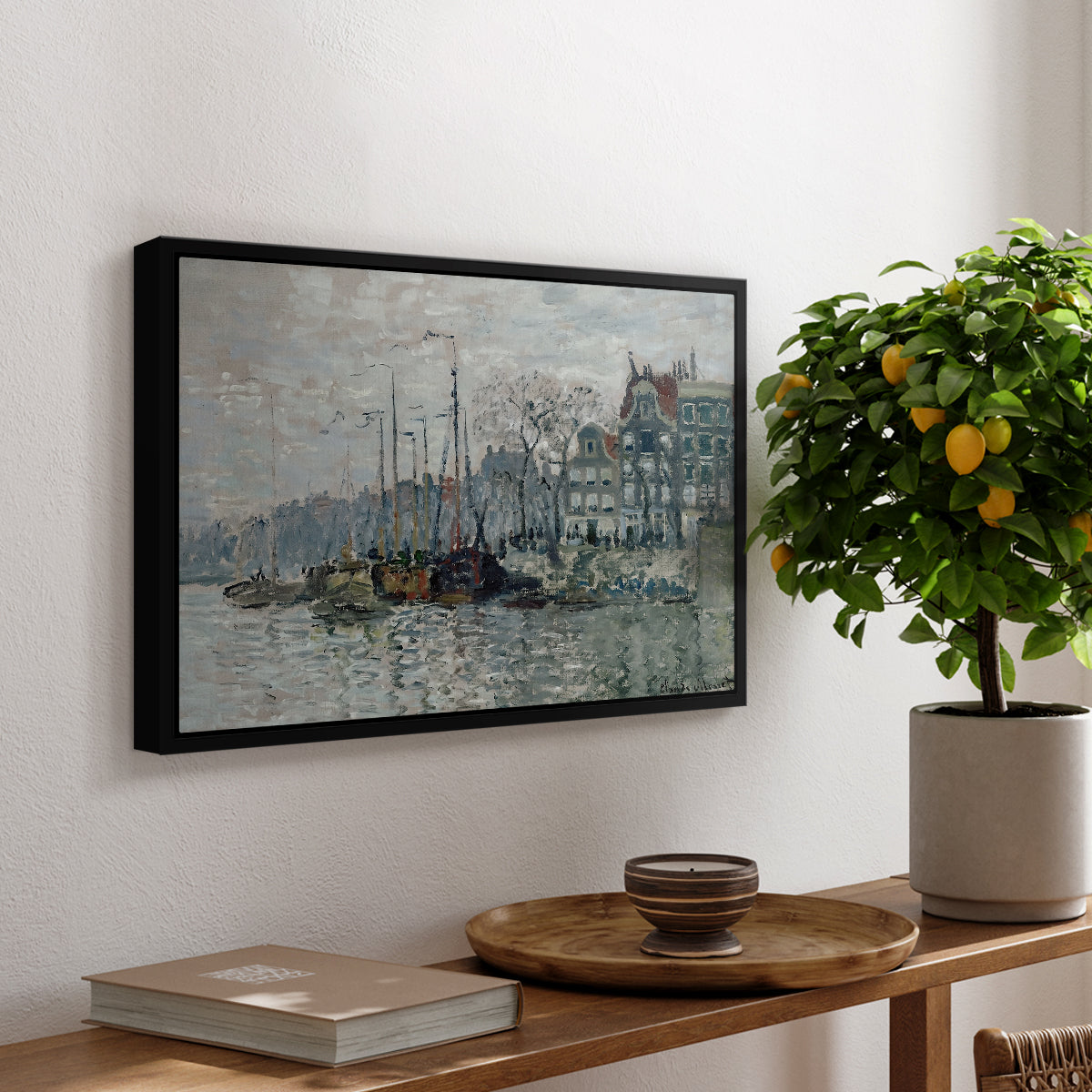 View of the Prins Hendrikkade and Kromme Waal in Amsterdam, 1874 by Claude Monet, presented in a black floater framed canvas featuring a canal scene with boats and buildings lining waterfront in Amsterdam, displayed above a hallway console table.