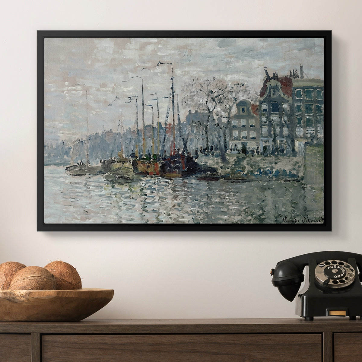 View of the Prins Hendrikkade and Kromme Waal in Amsterdam, 1874 by Claude Monet in a black floater framed canvas displayed above a console table in a hallway, featuring a harbor view with masts, houses, and reflections in water.