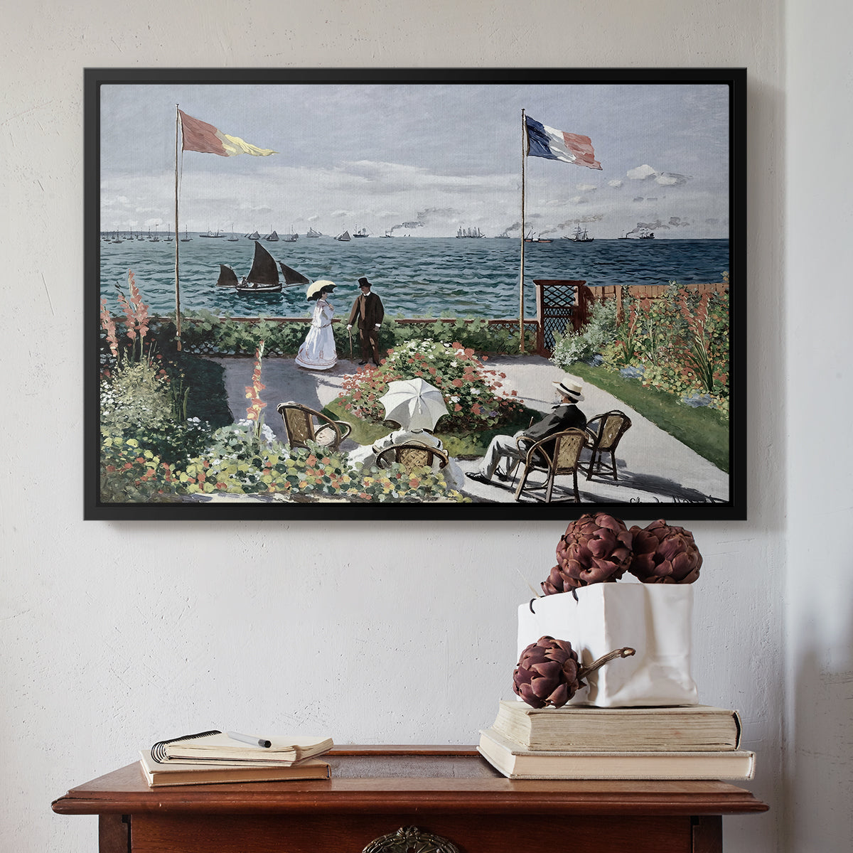 Black floater framed canvas featuring Garden at Sainte-Adresse, 1867 by Claude Monet above an entryway table in a minimalist foyer.