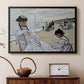Black floater framed canvas featuring a beach setting with people relaxing under umbrellas, displayed above a cabinet in a soft-toned living room.