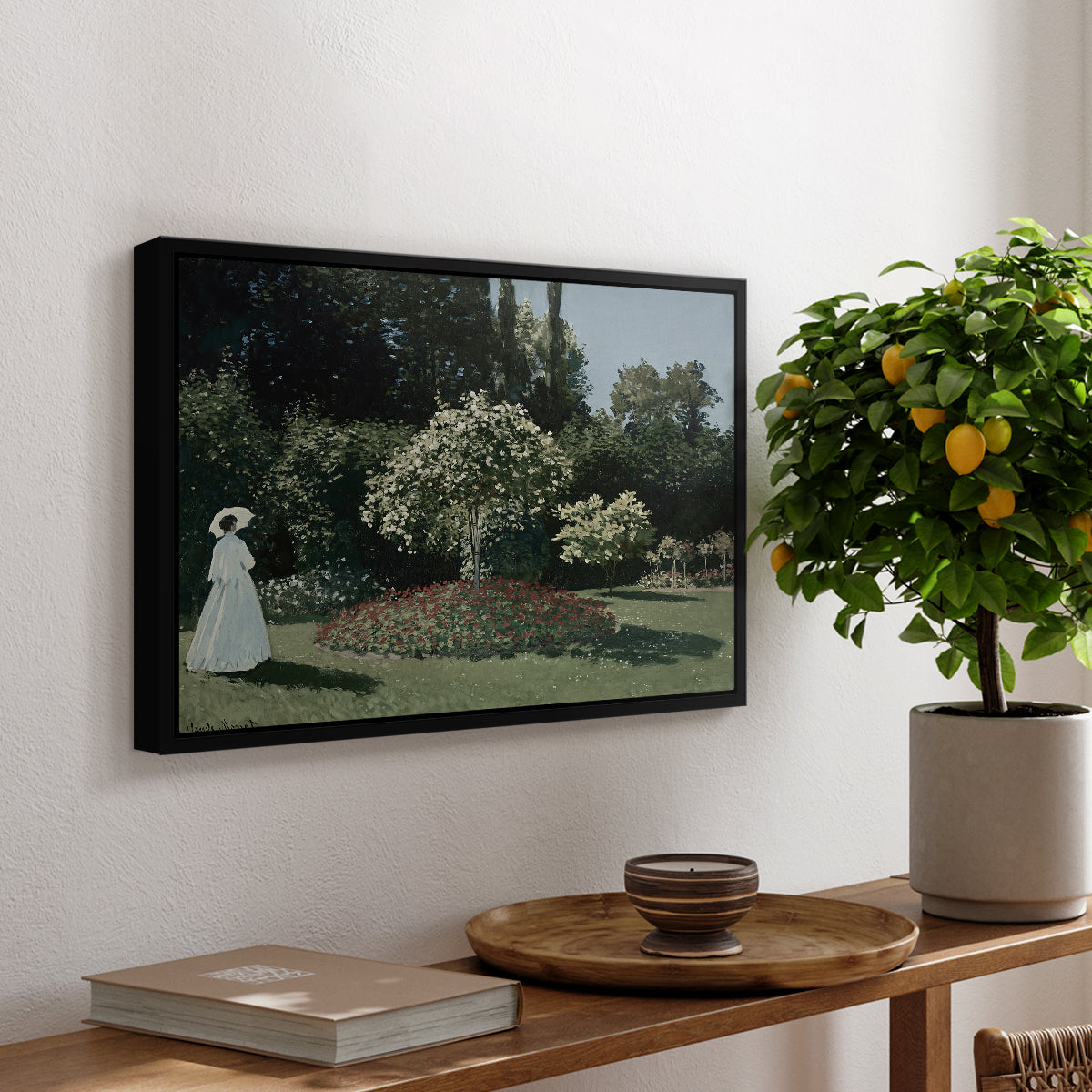 Woman in the Garden, Sainte-Adresse, 1867 by Claude Monet, presented in a black floater framed canvas featuring a woman standing in garden surrounded by flowers and greenery, displayed above a hallway console table.