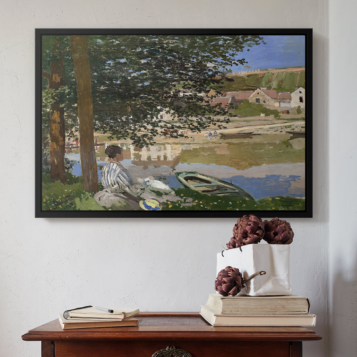 Black floater framed canvas featuring On the Bank of the Seine, Bennecourt, 1868 by Claude Monet above an entryway table in a minimalist foyer.