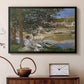 Black floater framed canvas featuring an impressionist landscape with people relaxing along the Seine, displayed above a cabinet in a soft-toned living room.