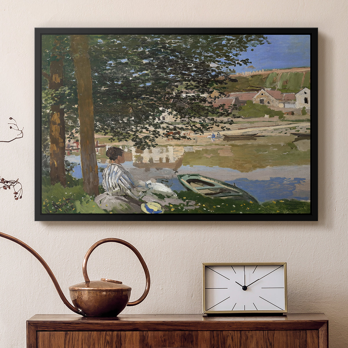 Black floater framed canvas featuring an impressionist landscape with people relaxing along the Seine, displayed above a cabinet in a soft-toned living room.