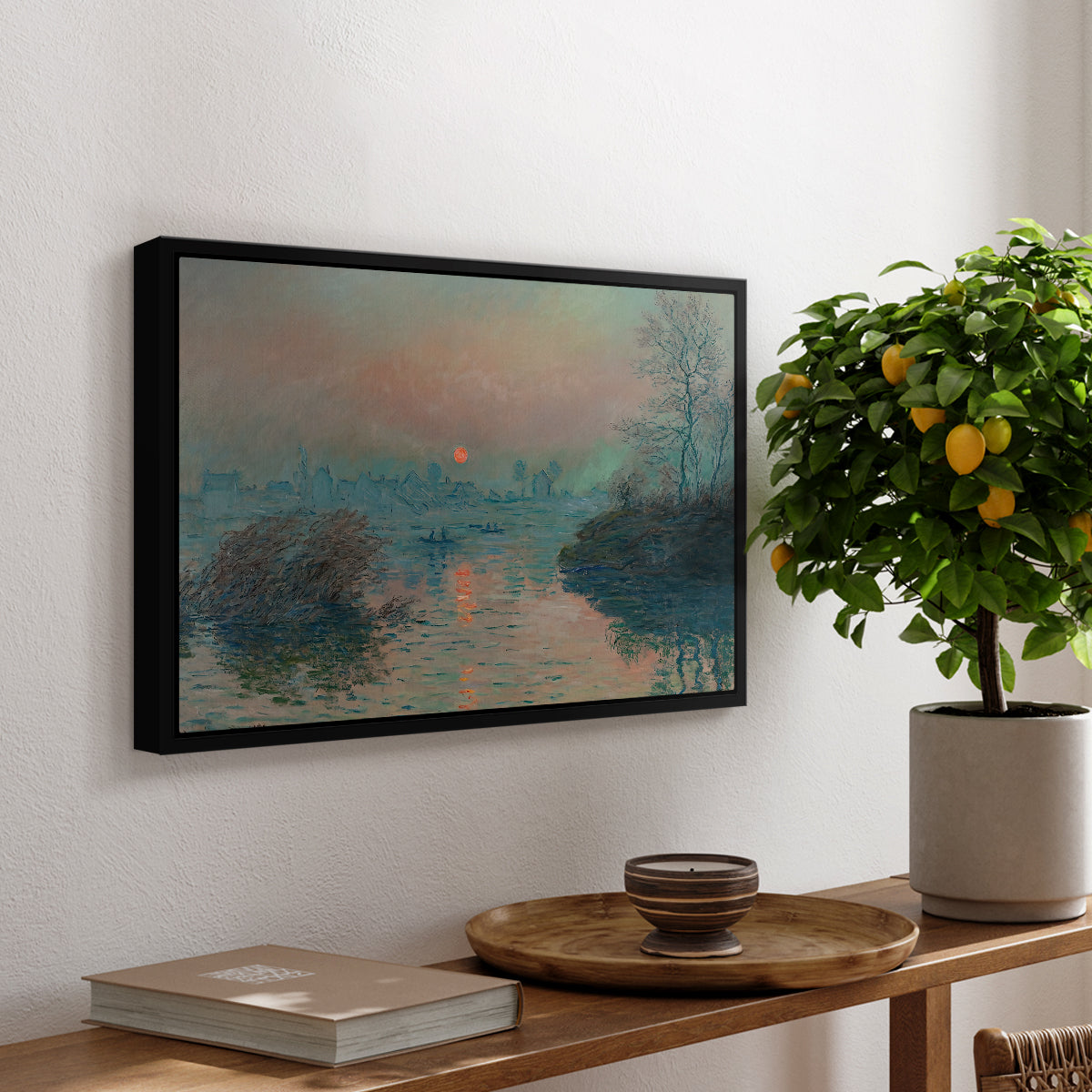 Sunset on the Seine at Lavacourt, Winter Effect, 1880 by Claude Monet, presented in a black floater framed canvas featuring a glowing sunset over snowy river landscape with soft reflections, displayed above a hallway console table.