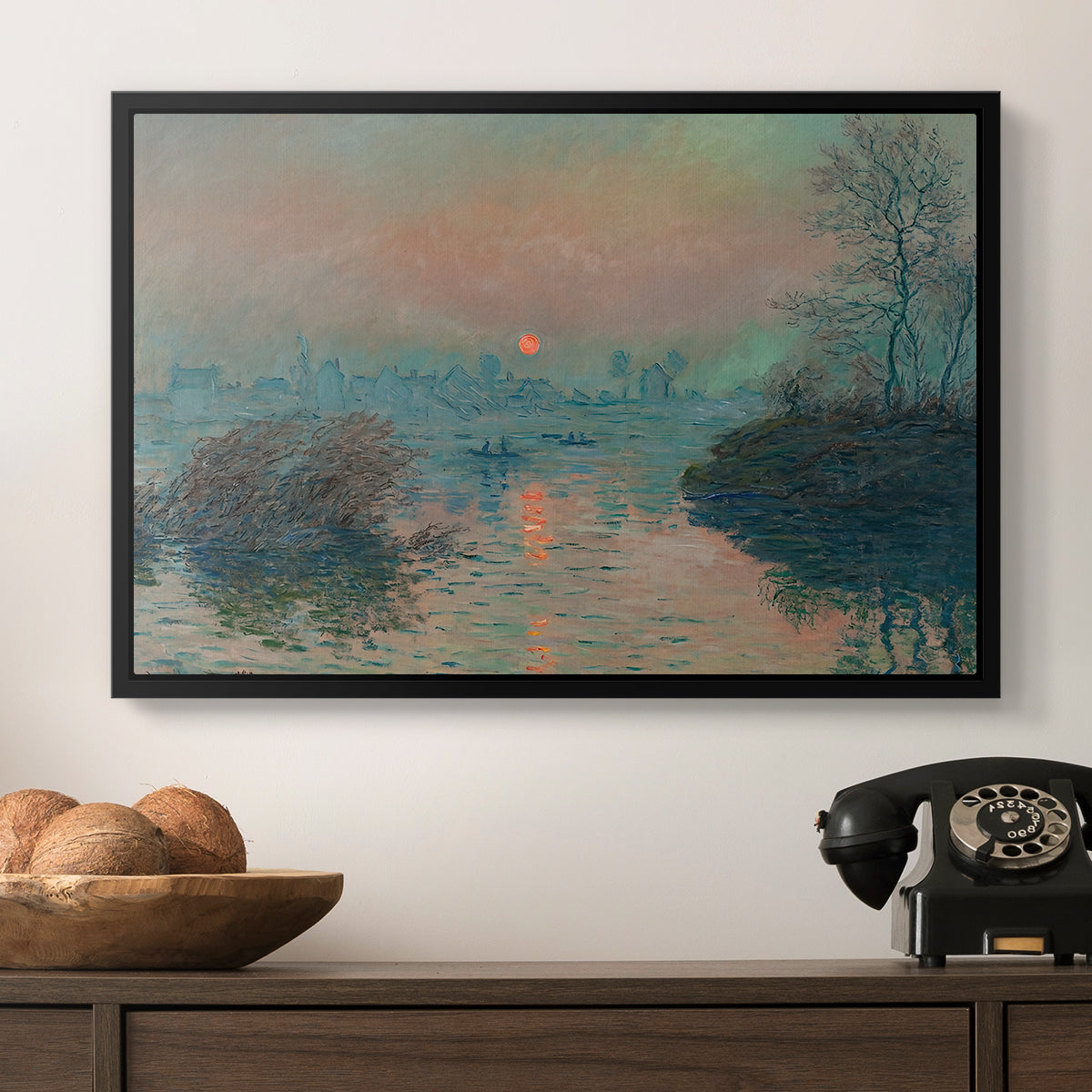 Sunset on the Seine at Lavacourt, Winter Effect, 1880 by Claude Monet in a black floater framed canvas displayed above a console table in a hallway, featuring an atmospheric landscape combining cold tones and warm sky.