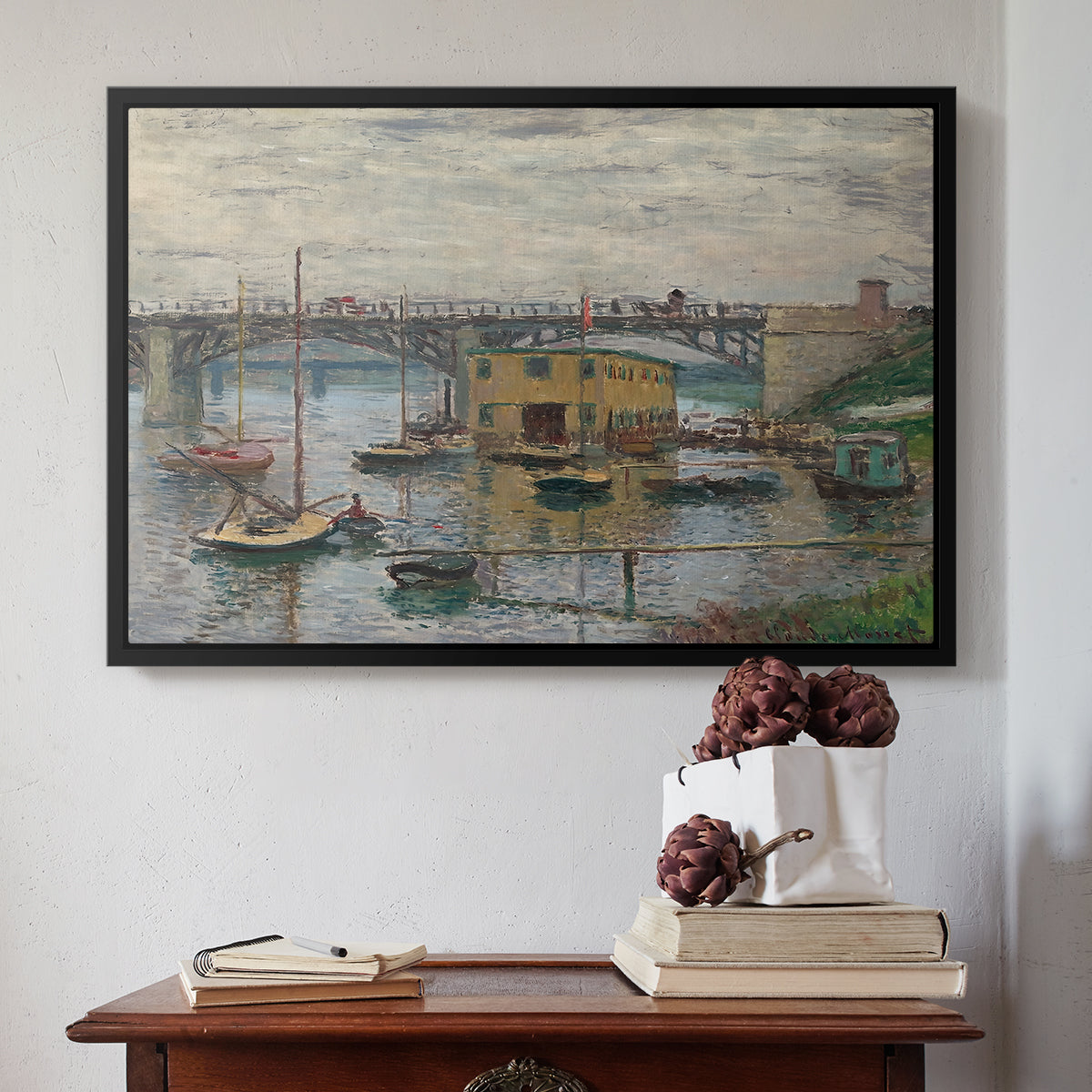 Black floater framed canvas featuring Bridge at Argenteuil on a Gray Day, c. 1876 by Claude Monet above an entryway table in a minimalist foyer.