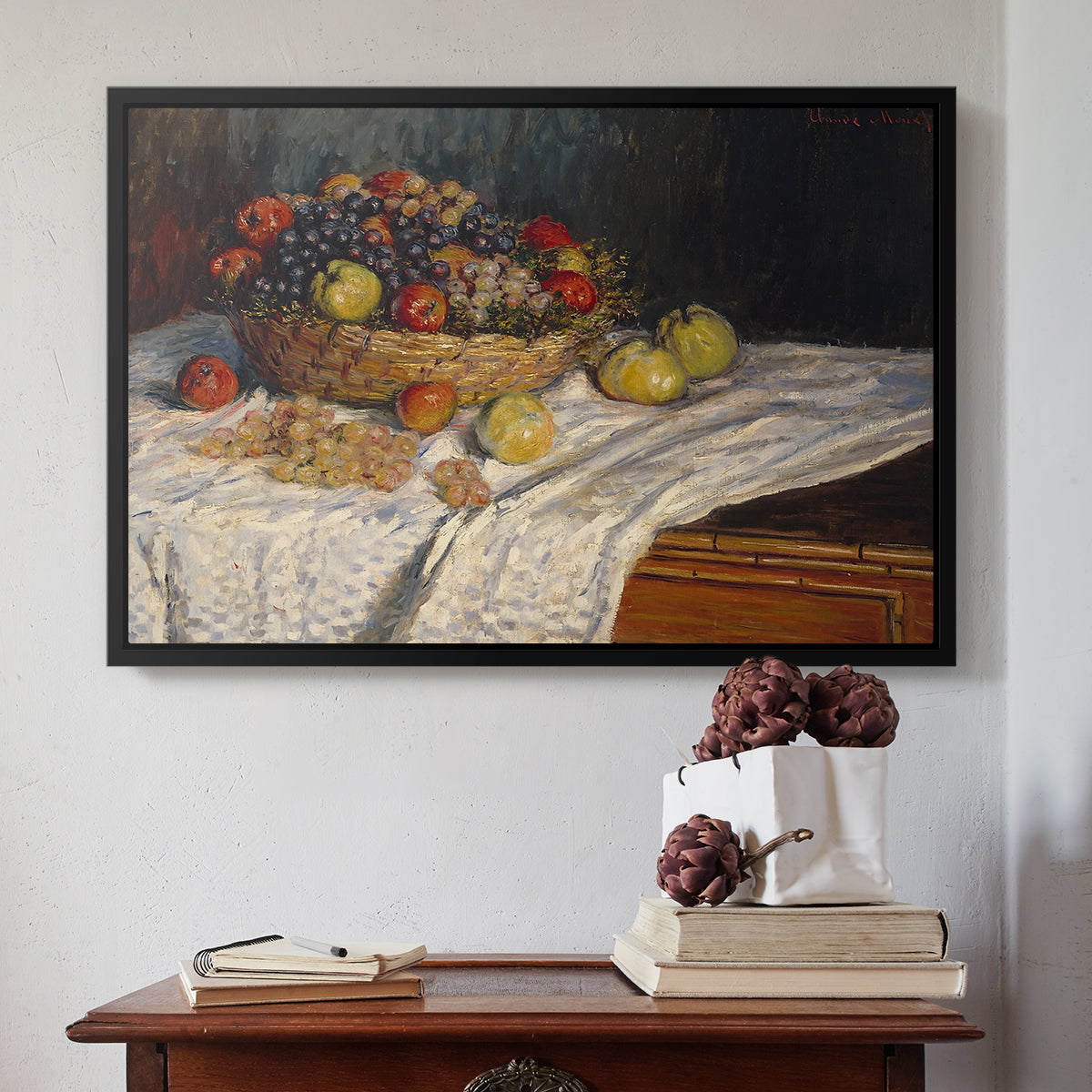 Black floater framed canvas featuring Still Life with Apples and Grapes, 1880 by Claude Monet above an entryway table in a minimalist foyer.