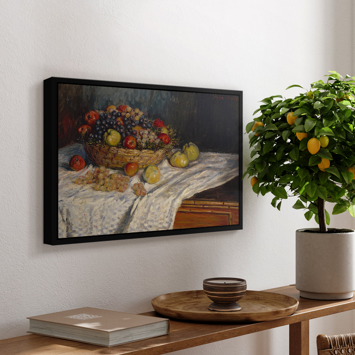 Still Life with Apples and Grapes, 1880 by Claude Monet, presented in a black floater framed canvas featuring an arrangement of apples and grapes on table with soft natural light, displayed above a hallway console table.