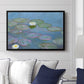 Water Lilies (Nymphéas), 1897-1899 by Claude Monet displayed above a sofa in a living room in a black floater frame, featuring an impressionist pond scene with lily pads and soft reflections.