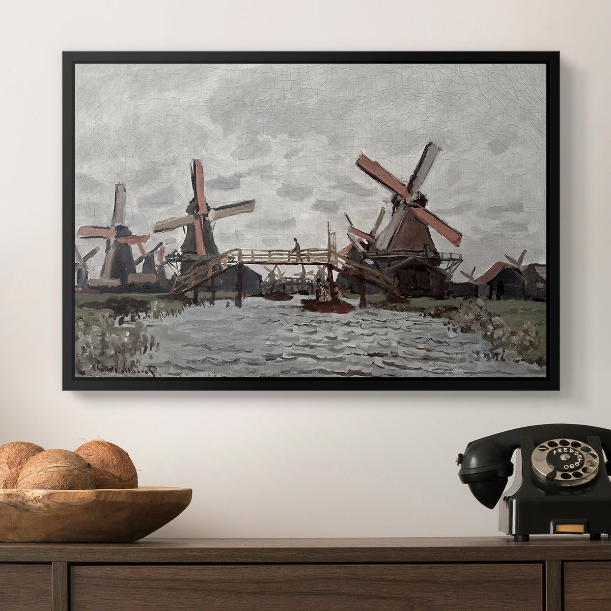 Windmills near Zaandam, 1871 by Claude Monet in a black floater framed canvas displayed above a console table in a hallway, featuring a landscape featuring windmills and low horizon sky.