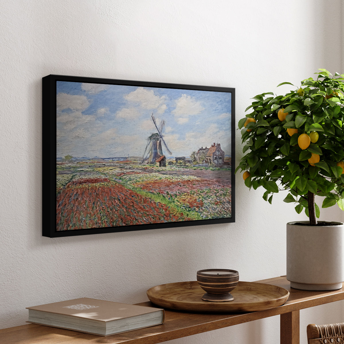 Tulip Fields with the Rijnsburg Windmill, 1886 by Claude Monet, presented in a black floater framed canvas featuring colorful rows of tulip fields leading toward distant windmill, displayed above a hallway console table.