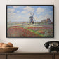 Tulip Fields with the Rijnsburg Windmill, 1886 by Claude Monet in a black floater framed canvas displayed above a console table in a hallway, featuring a rural scene with patterned rows of flowers and windmill.