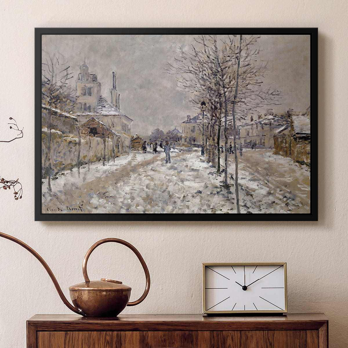 Black floater framed canvas featuring a quiet boulevard blanketed in snow with distant figures, displayed above a cabinet in a soft-toned living room.