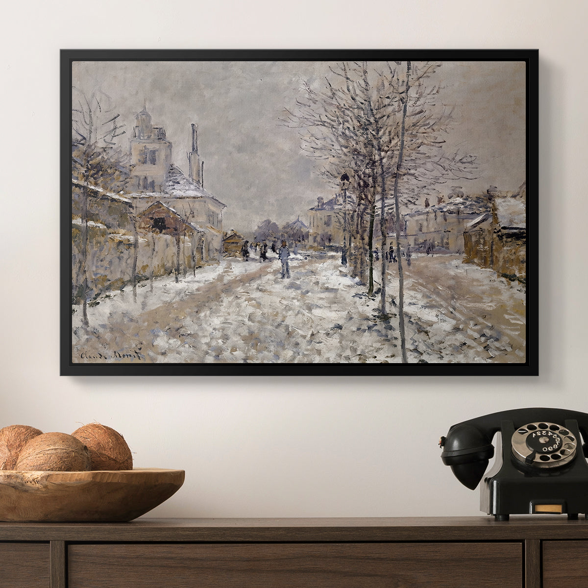 The Boulevard de Pontoise at Argenteuil, Snow Effect, 1875 by Claude Monet in a black floater framed canvas displayed above a console table in a hallway, featuring an urban winter landscape with muted tones and soft light.