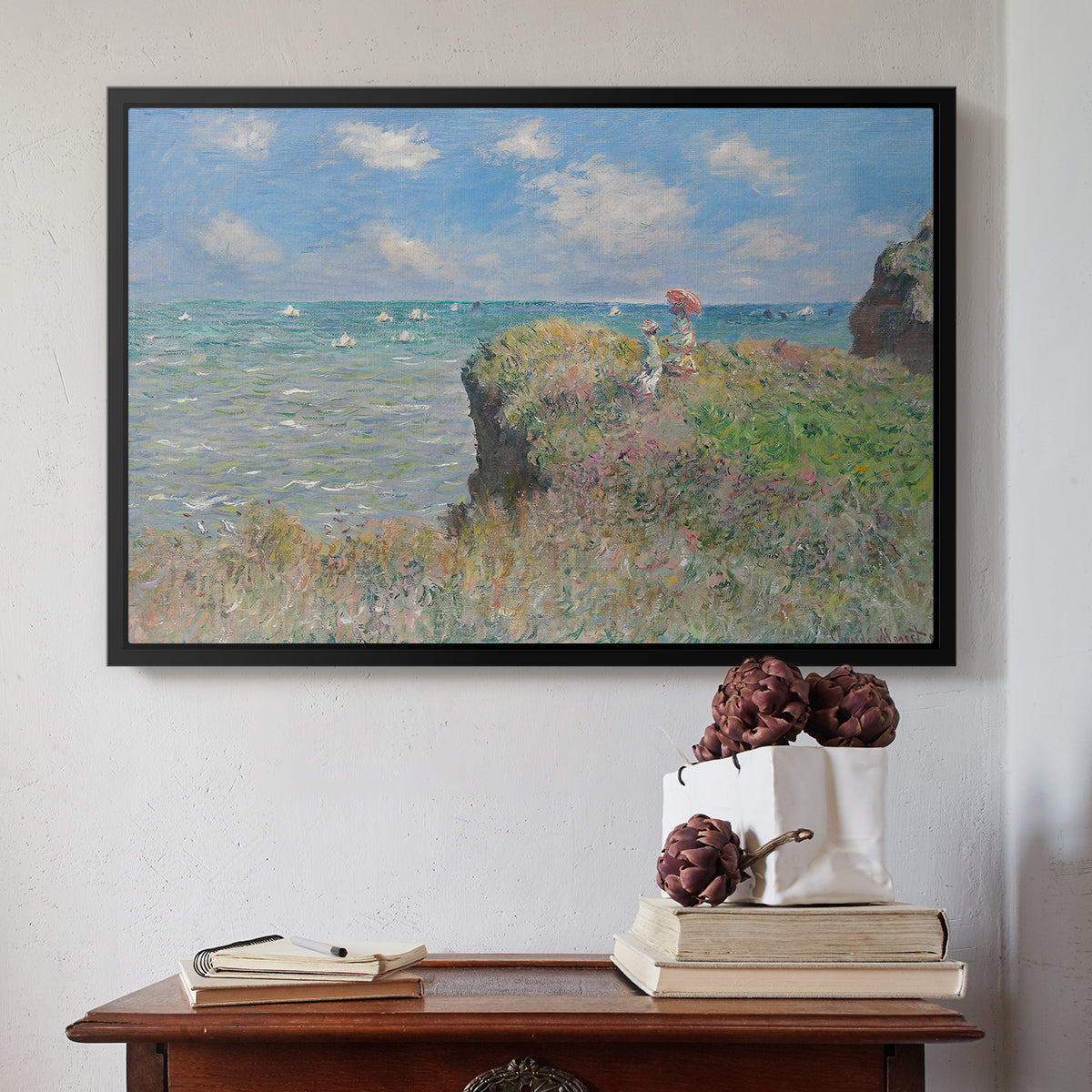 Black floater framed canvas featuring The Cliff Walk at Pourville, 1882 by Claude Monet above an entryway table in a minimalist foyer.