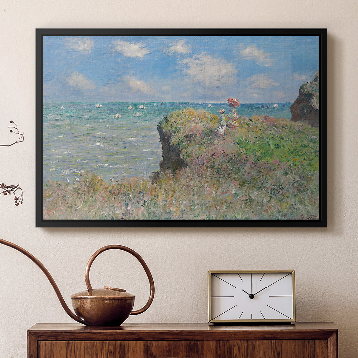 Black floater framed canvas featuring a coastal cliff scene with grass, wind, and expansive sea view, displayed above a cabinet in a soft-toned living room.