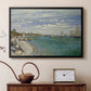 Black floater framed canvas featuring an impressionist coastal view with colorful sails and shoreline activity, displayed above a cabinet in a soft-toned living room.