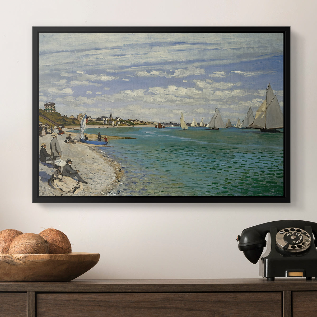 Regatta at Sainte-Adresse, 1867 by Claude Monet in a black floater framed canvas displayed above a console table in a hallway, featuring a nautical scene with boats racing near seaside town.