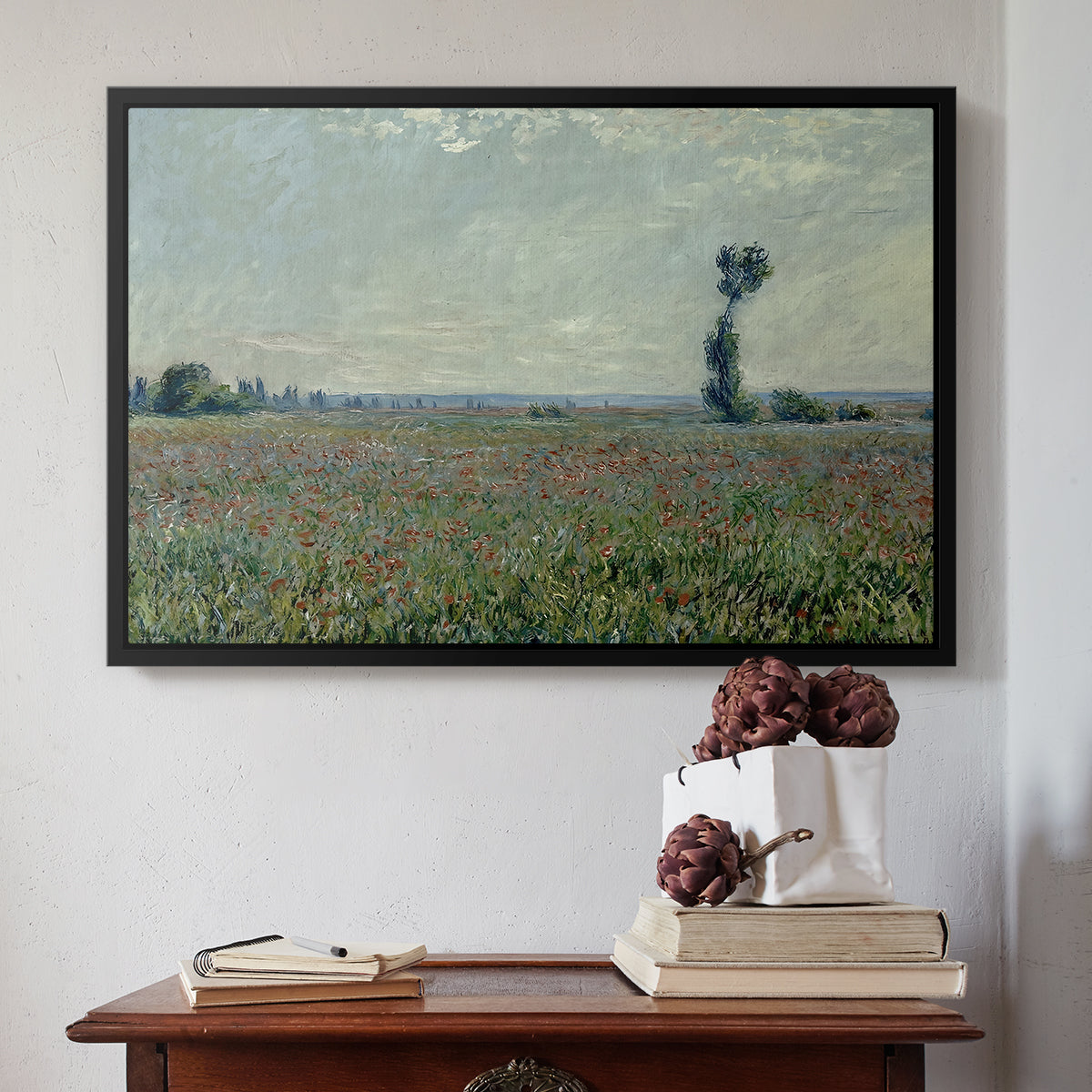 Black floater framed canvas featuring Poppy Field, 1881 by Claude Monet above an entryway table in a minimalist foyer.