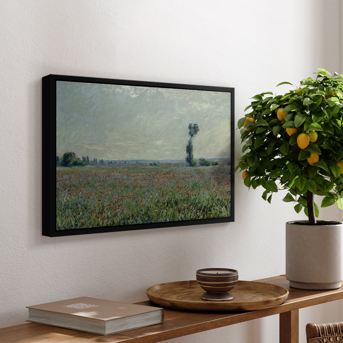 Poppy Field, 1881 by Claude Monet, presented in a black floater framed canvas featuring a wide field of red poppies stretching across countryside under open sky, displayed above a hallway console table.