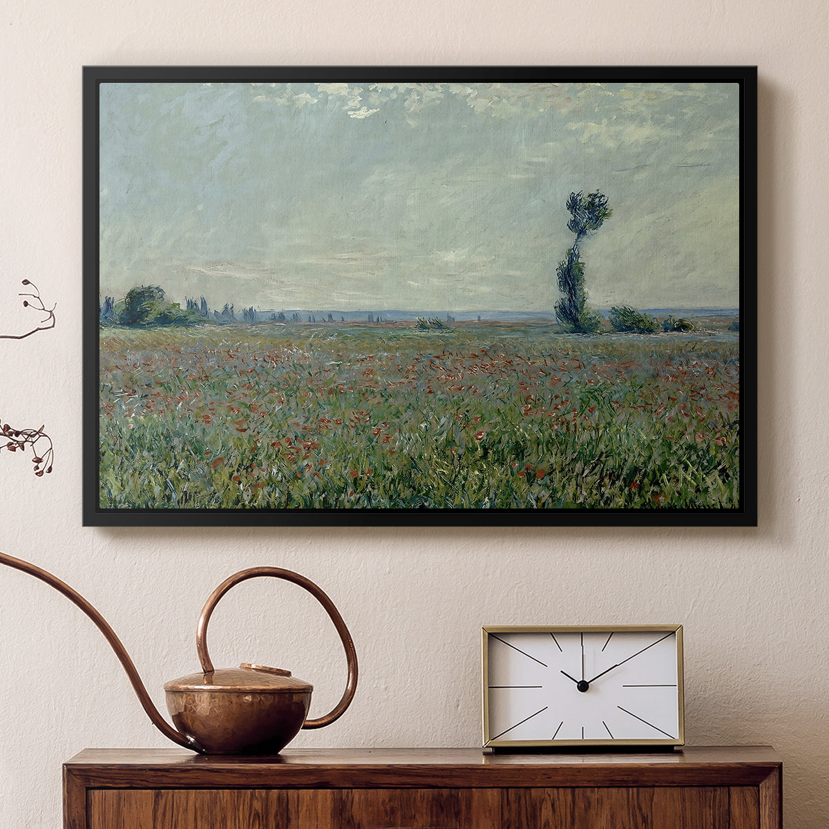 Black floater framed canvas featuring a rural meadow with scattered poppies and soft horizon, displayed above a cabinet in a soft-toned living room.