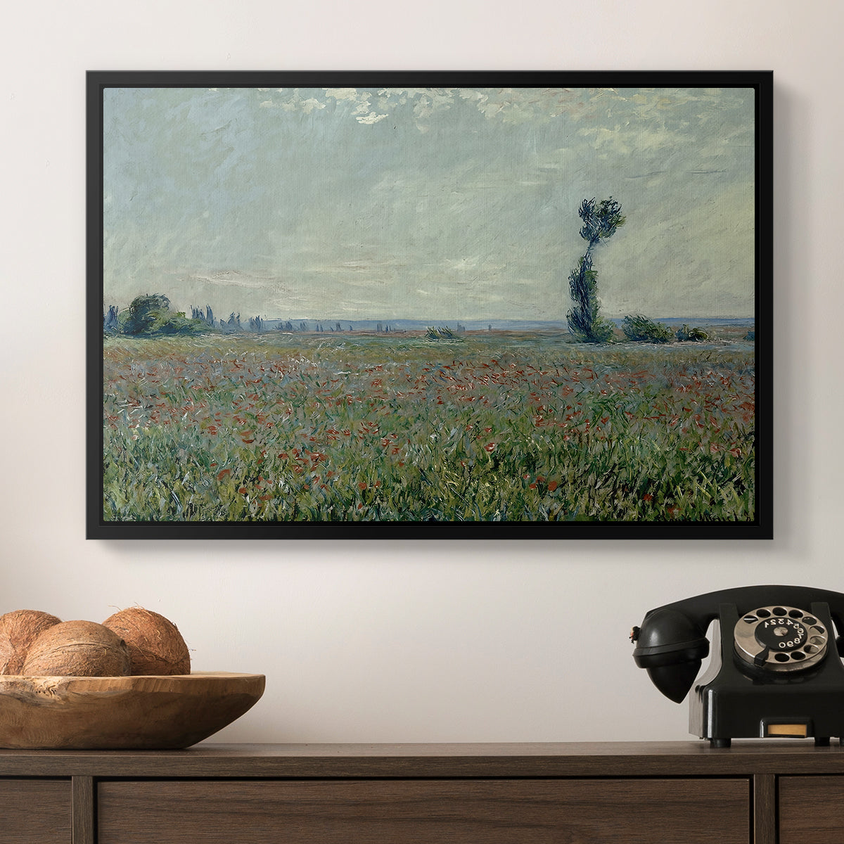 Poppy Field, 1881 by Claude Monet in a black floater framed canvas displayed above a console table in a hallway, featuring a natural field scene with vibrant red flowers.