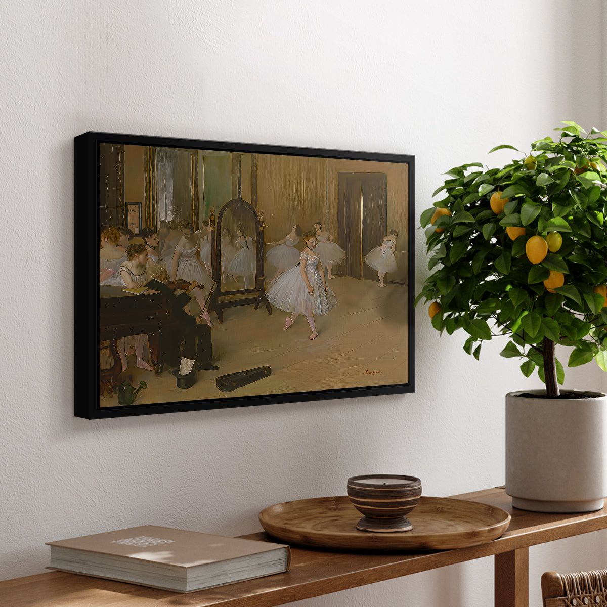 The Dancing Class, c. 1870 by Edgar Degas, presented in a black floater framed canvas featuring a ballet class with dancers practicing positions under instructor guidance, displayed above a hallway console table.