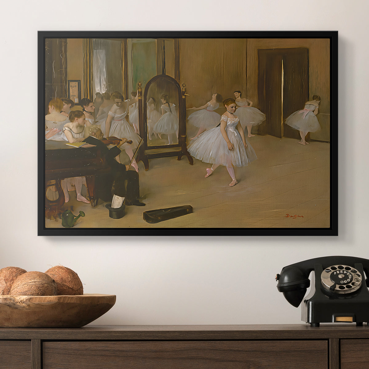 The Dancing Class, c. 1870 by Edgar Degas in a black floater framed canvas displayed above a console table in a hallway, featuring a group of dancers mid-practice with teacher overseeing.