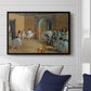 The Dance Foyer at the Opera on the Rue Le Peletier, 1872 by Edgar Degas displayed above a sofa in a living room in a black floater frame, featuring an interior scene of dancers waiting and stretching in large studio.